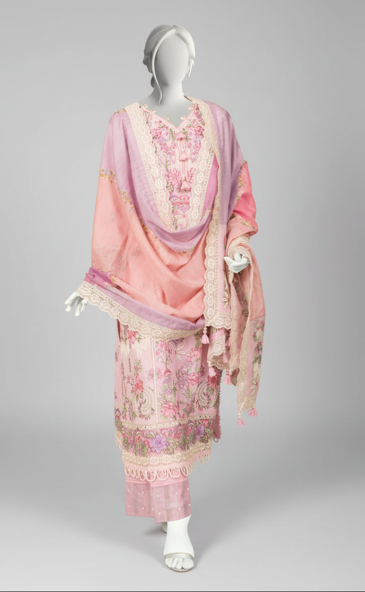 Mannequin wearing a pink embroidered outfit in a room with a painting and fireplace.