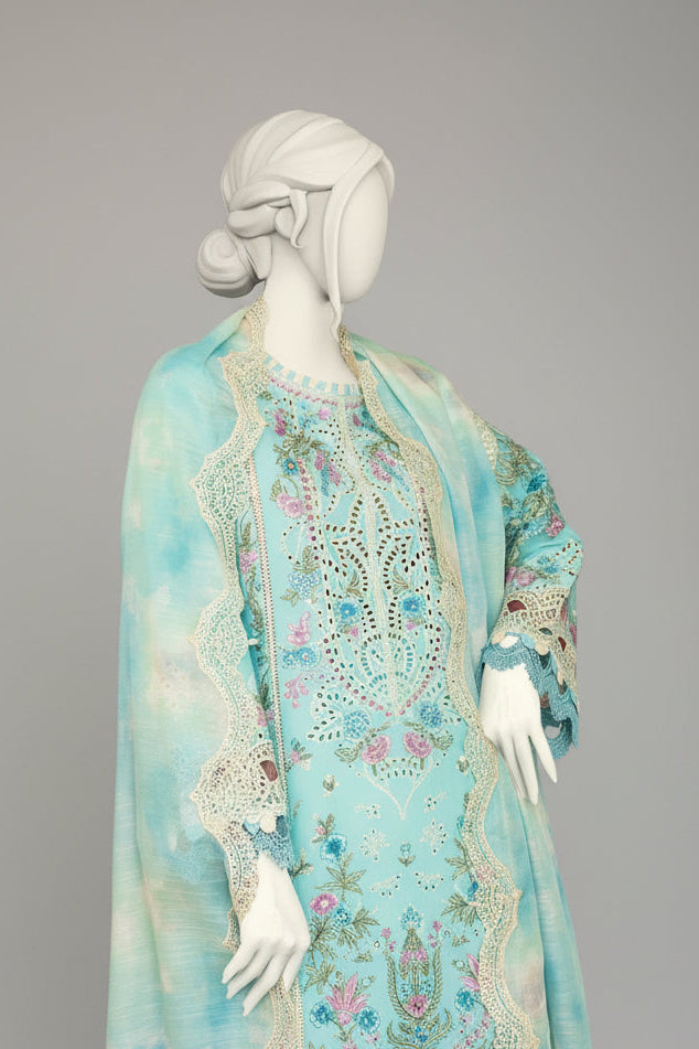 Mannequin wearing a light blue embroidered dress with a matching shawl in a room with checkered floor.