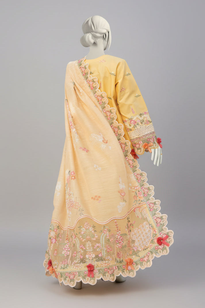 Yellow saree with floral patterns on a mannequin against a garden background