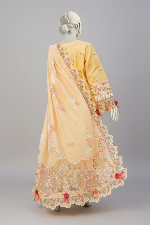 Yellow saree with floral patterns on a mannequin against a garden background