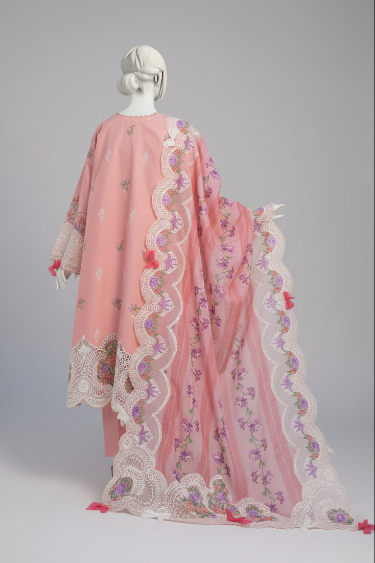 Mannequin wearing a pink embroidered outfit with floral patterns in an outdoor setting.