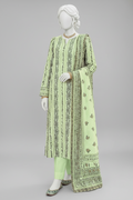 A light green traditional three-piece salwar kameez suit displayed on a mannequin in an outdoor garden setting decorated with flowers and a floral bench.