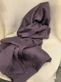A draped piece of textured purple fabric with small scattered silver rhinestone accents, displayed on a white draped chair.