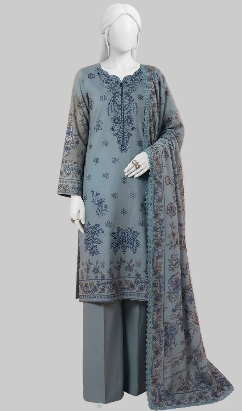A three-piece women's traditional outfit displayed on a white mannequin, featuring a slate blue-gray kurta with dark blue floral embroidery, matching wide-leg trousers, and a coordinating dupatta, set against a soft peach-pink background.